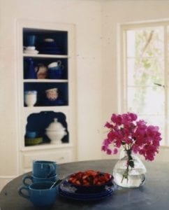 white and blue cupboard, fresh bougainvillea flowers, white walls