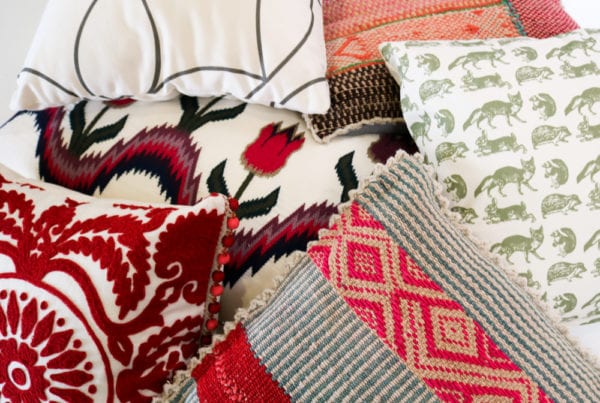 Assortment of different patters and textures of red and green throw pillows