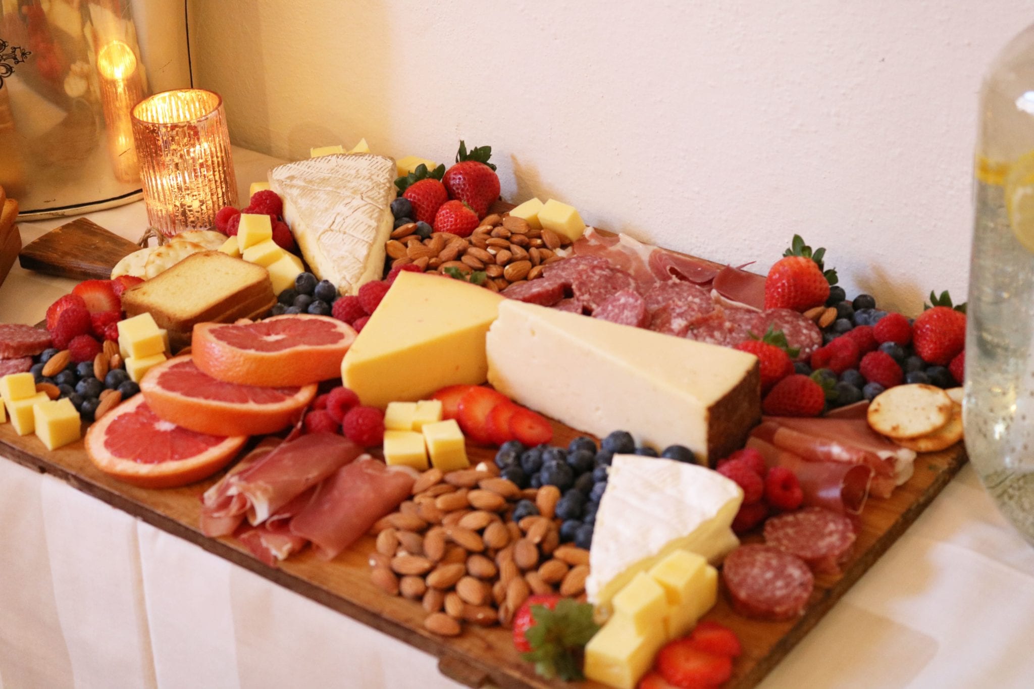 Colorful cheese board with meat, nuts and fruit