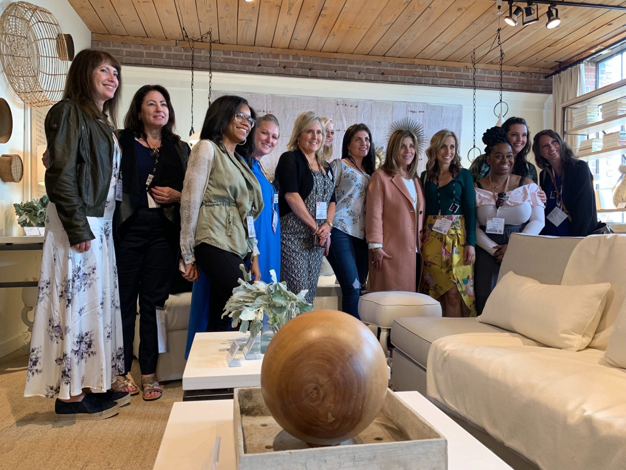 Group of women standing together in a living room with white and neutral colored furniture