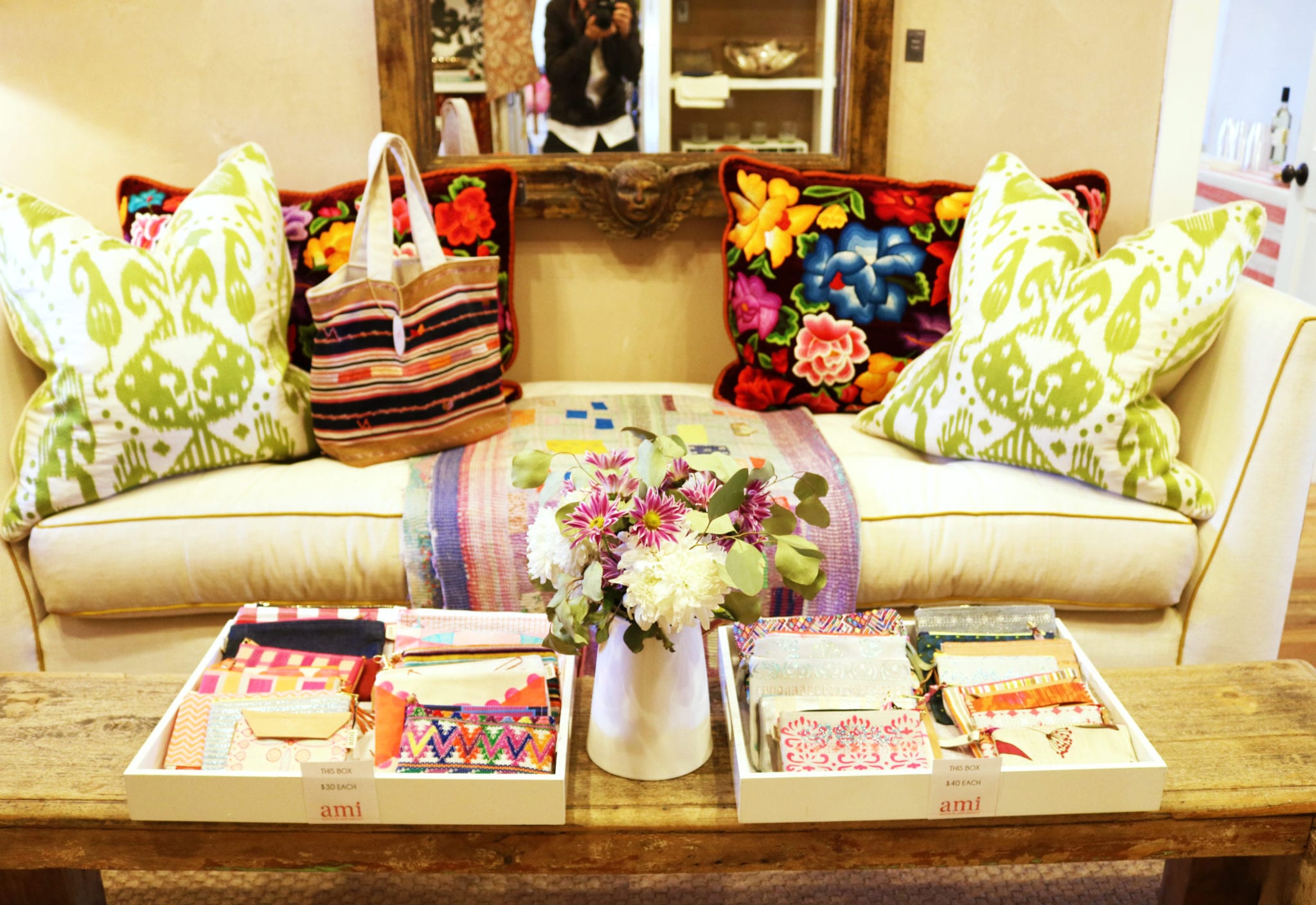 Sofa with multiple colorful bohemian pillows and coffee table with global patterned texture samples in trays